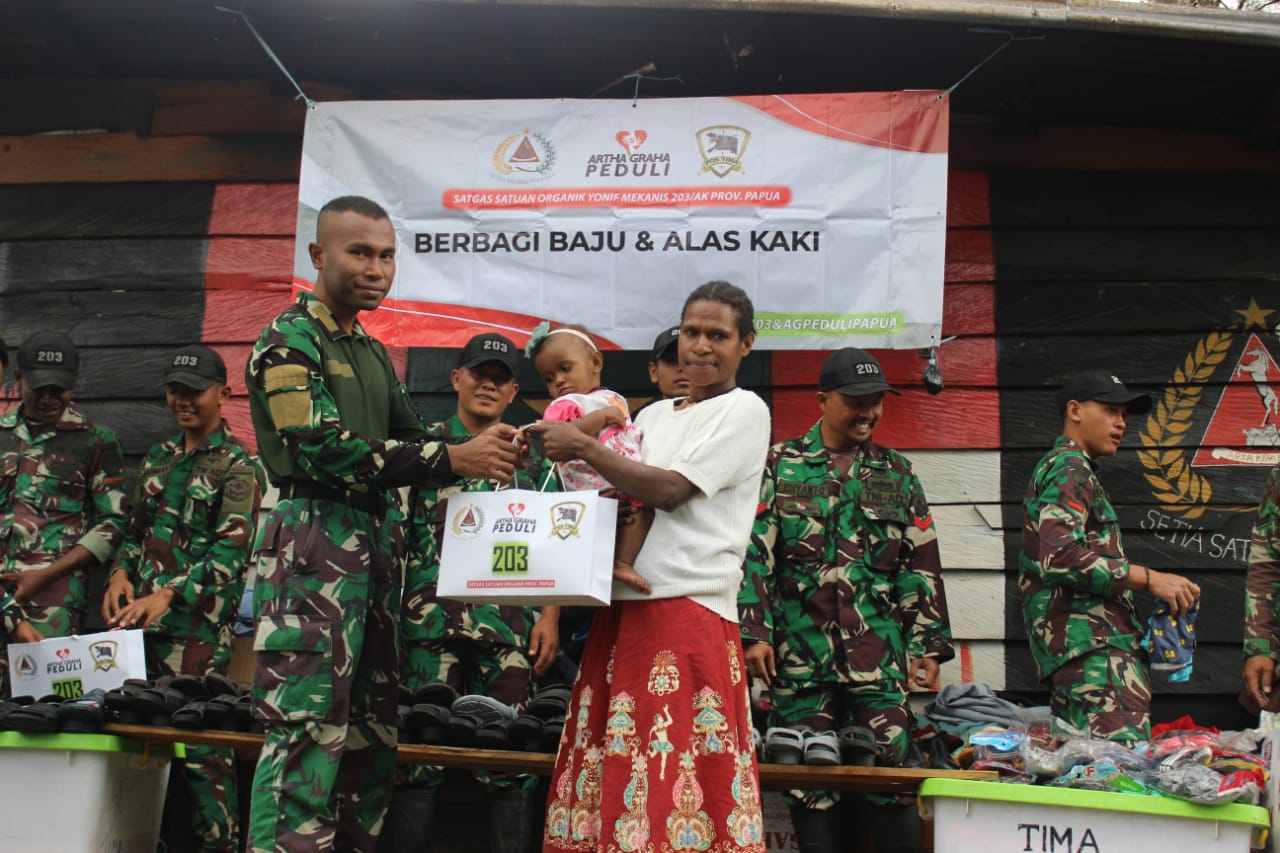 Satgas Yonif Mekanis 203/AK Bersama Artha Graha Berbagi Pakaian Untuk Masyarakat Desa Tima