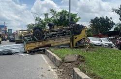 Akibat Ban Pecah, Truk Muatan Baja Ringan Terbalik